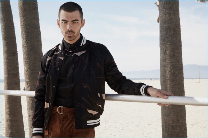 Singer Joe Jonas wears a Valentino bomber jacket with a Dior Homme shirt and necklace. Jonas also sports 3.1 Phillip Lim trousers.