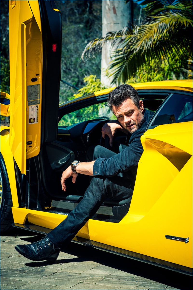 Getting out a yellow 2017 Lamborghini Aventador S Coupé, Josh Duhamel wears a John Varvatos shirt and jacket. Duhamel also wears Nudie Jeans denim, and a Panerai watch.