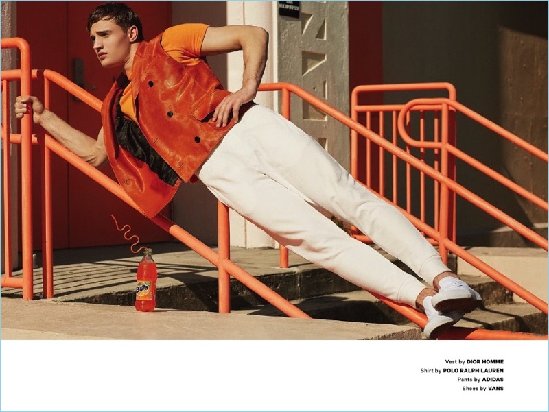 Sporting an orange look, Julian Schneyder dons a Dior Homme vest with a POLO Ralph Lauren shirt. The Austrian model also wears Adidas pants and Vans shoes.