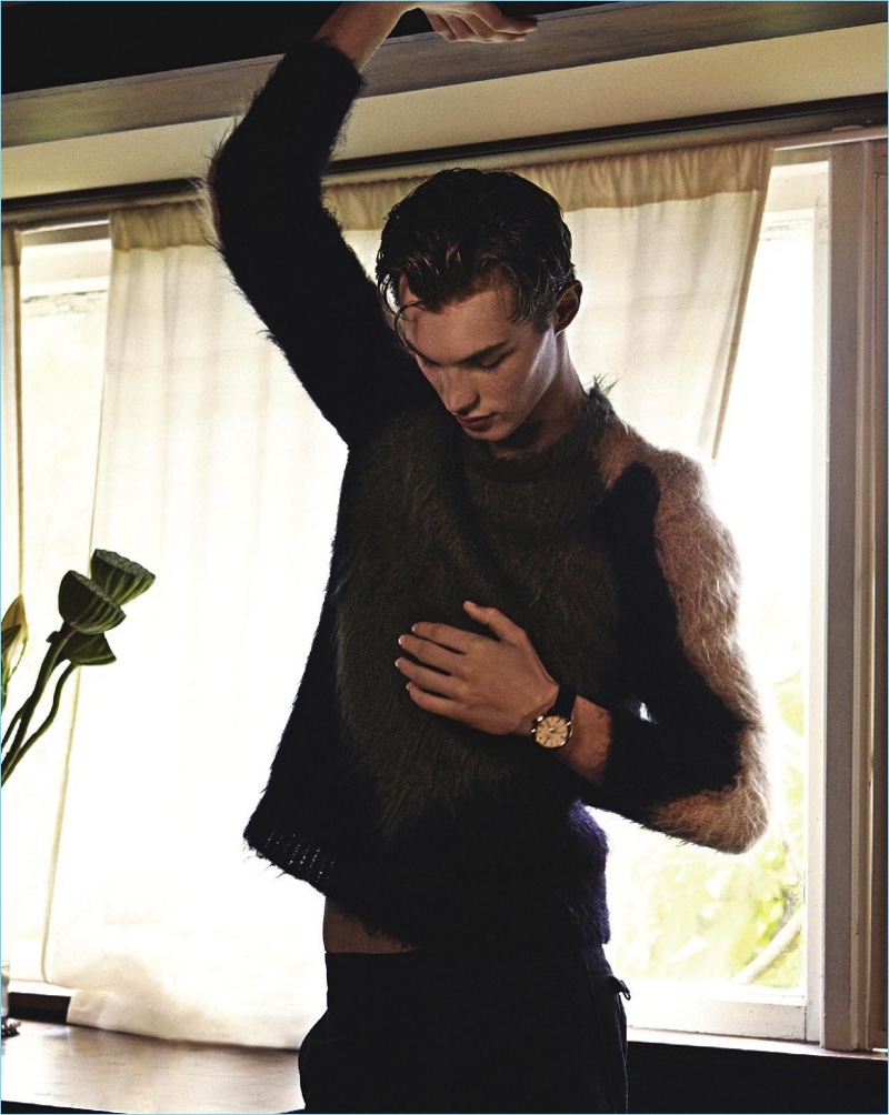 Appearing in an editorial for GQ Australia, Kit Butler wears a sweater and trousers by Louis Vuitton with a Jaeger-LeCoultre watch.