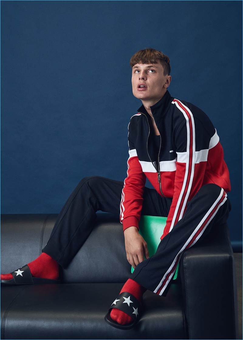 Going sporty, Vanya wears a Givenchy track jacket $995 and pants $1,495 with slide sandals $325. Vanya also models an Ann Demeulemeester sheer tank $235 and Comme des Garçons classic iPad case. 