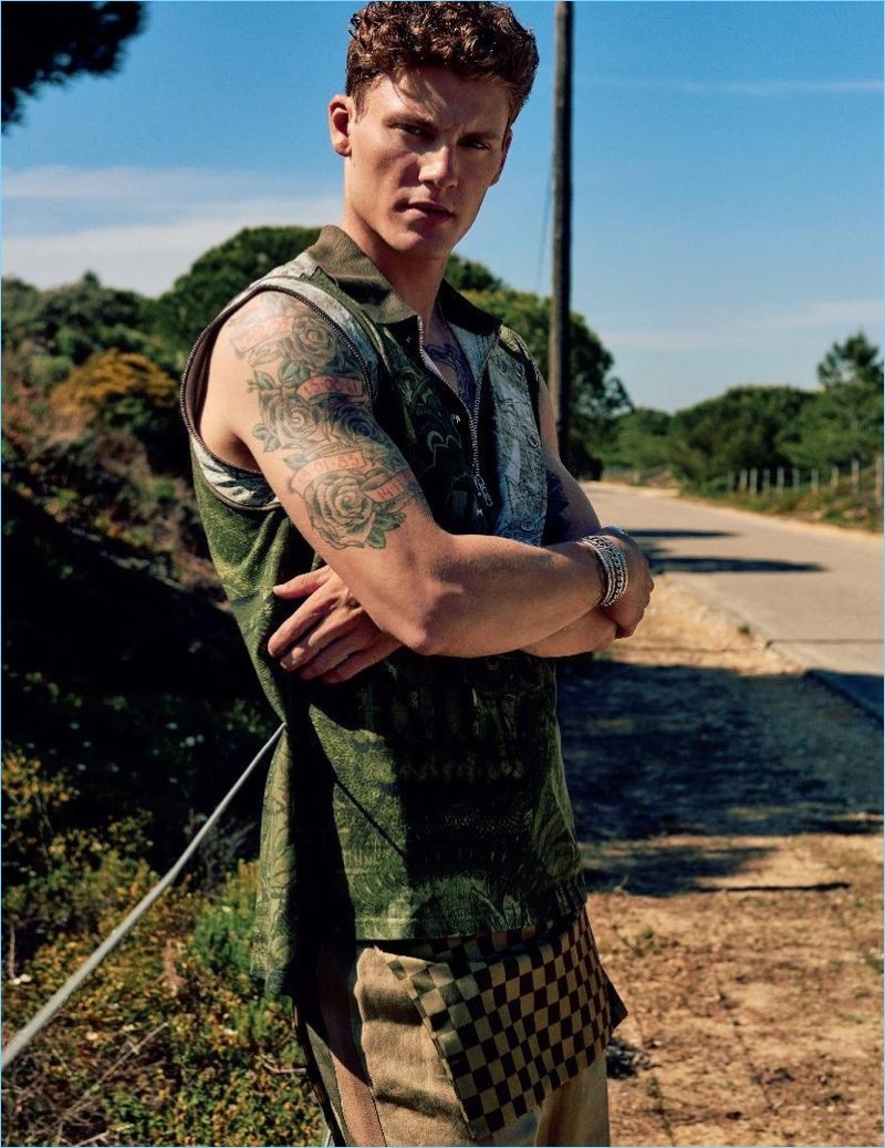 Crossing his arms, Mikkel Jensen wears a tank and cropped pullover from Lanvin with Givenchy pants.