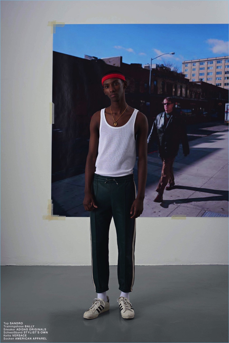 Myles Dominique wears a Sandro tank with Bally track pants and Adidas Originals sneakers.