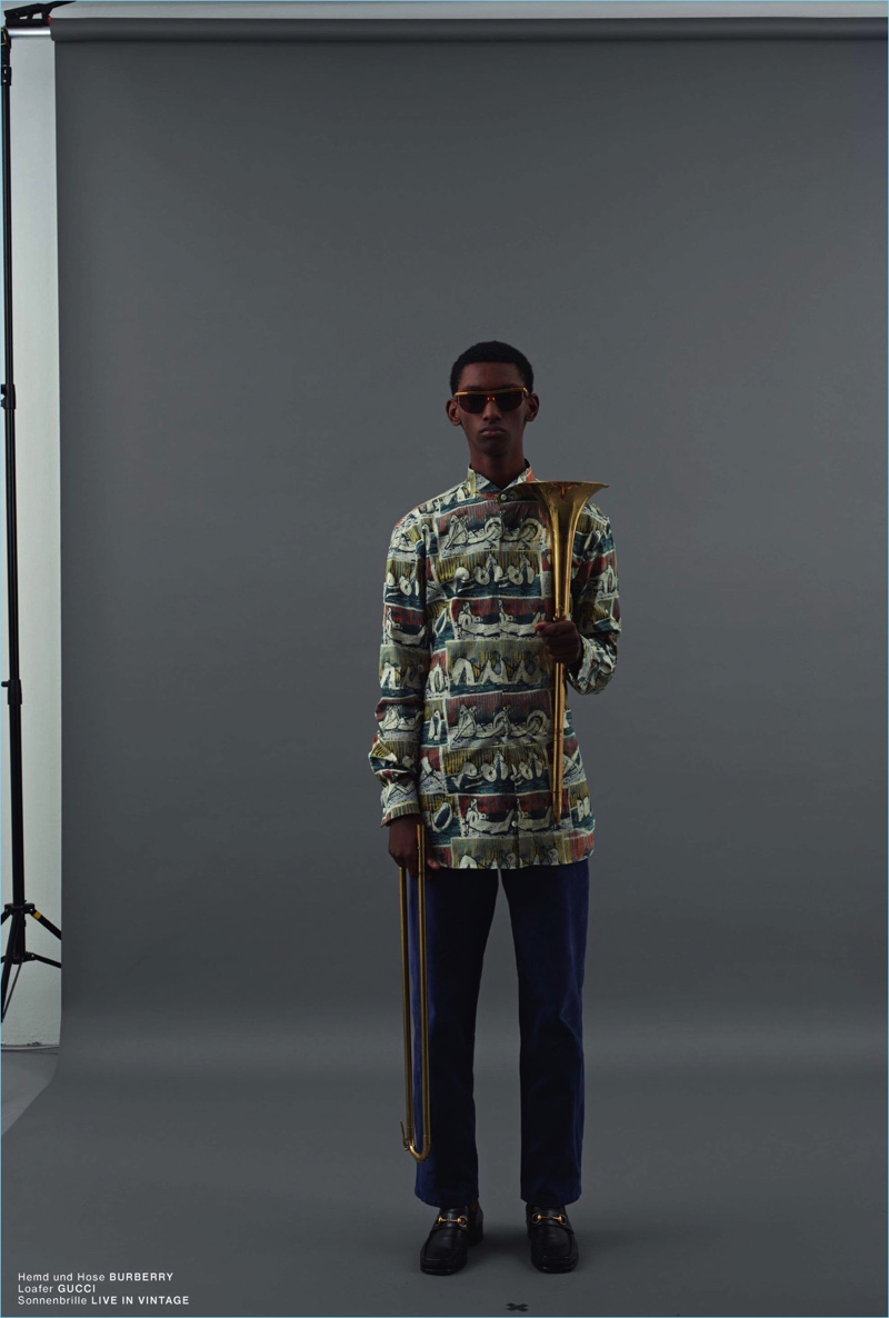 Embracing prints, Myles Dominique models a shirt and pants from Burberry. He also sports Gucci loafers and Live in Vintage sunglasses.