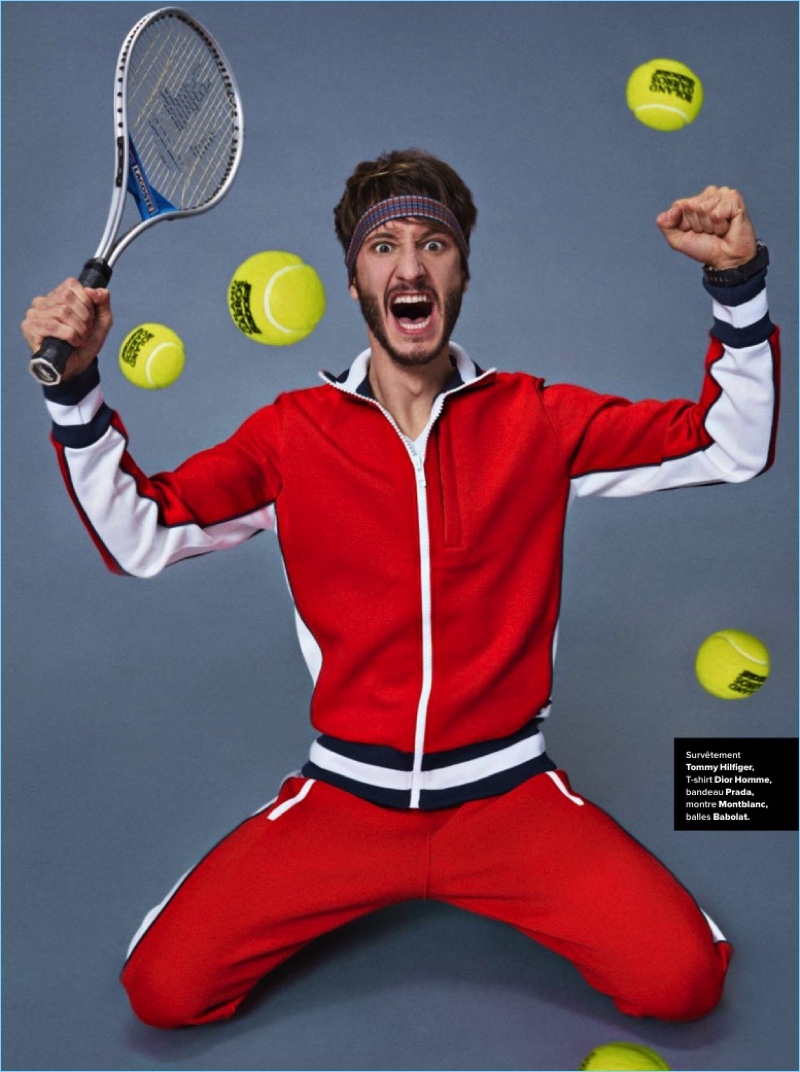 Posing for a cheeky image, Pierre Niney rocks a Tommy Hilfiger tracksuit with a Dior Homme tee, and Prada headband.