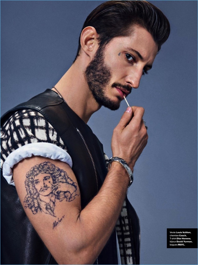 Channeling his inner bad boy, Pierre Niney wears a Louis Vuitton leather vest with a graphic Coach t-shirt.