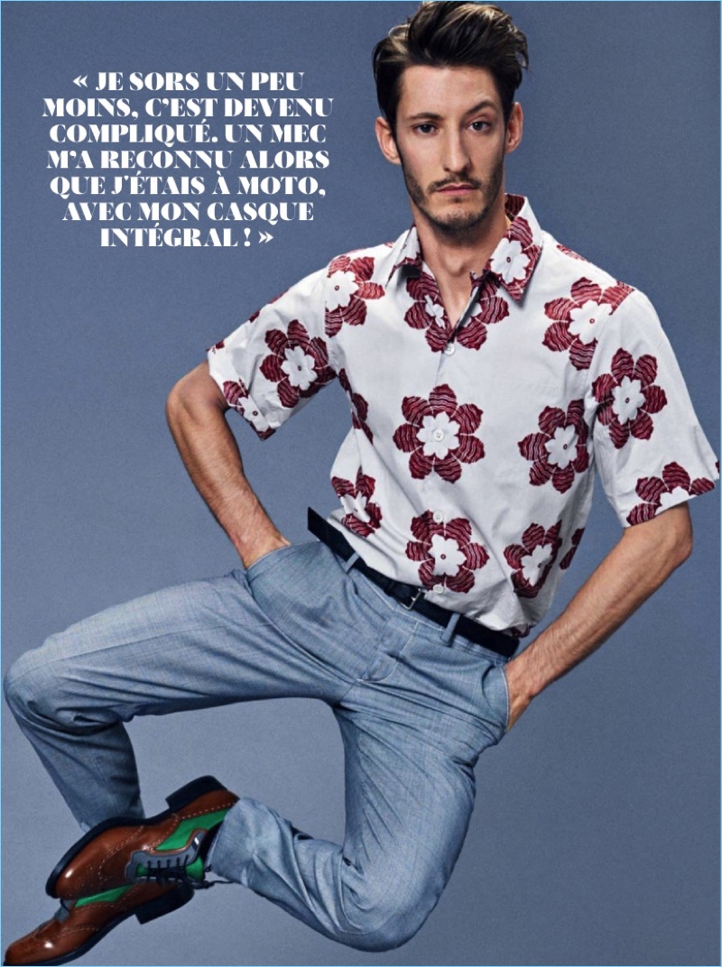 Embracing classic summer style, Pierre Niney dons a shirt, trousers, belt, and shoes by Prada.