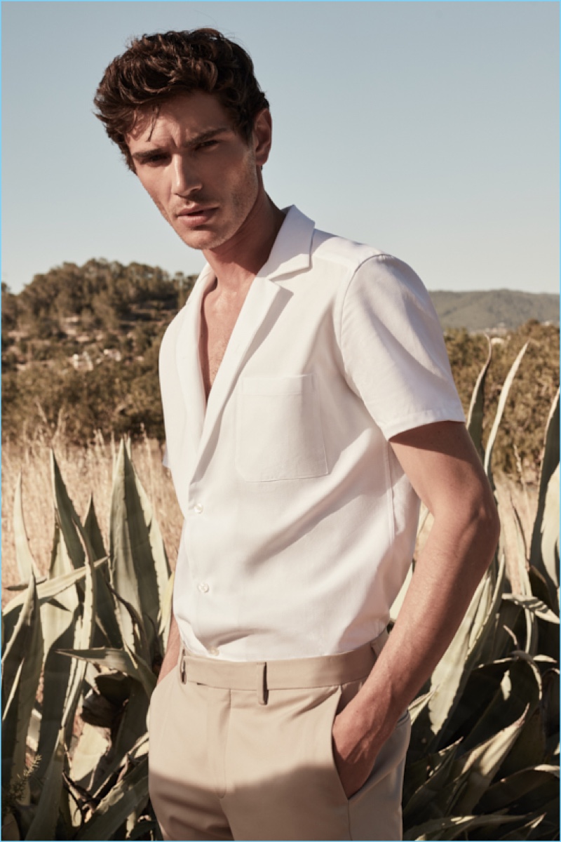 French model Julien Sabaud wears a Reiss white Cuban-collar shirt $145 with slim-fit chinos $180.