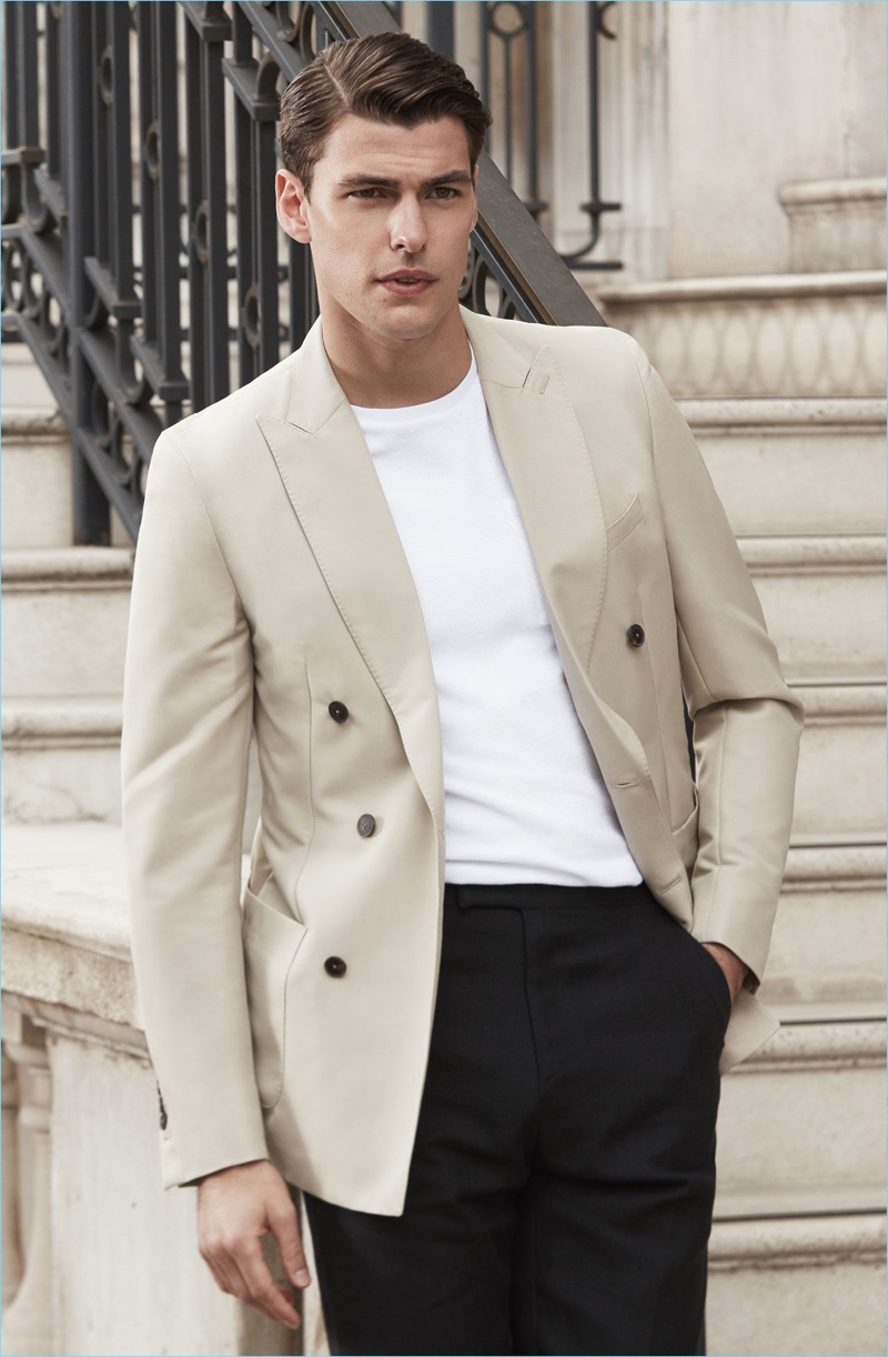 A smart vision, Filip Wolfe wears a Reiss double-breasted blazer $620 with a pocket t-shirt $95, and slim-leg trousers.