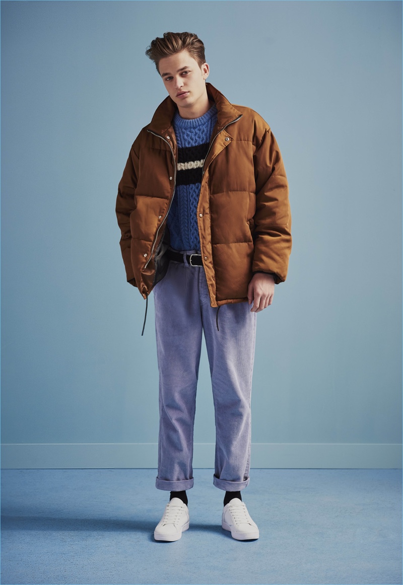 Denis channels relaxed 90s style in a down jacket, cable-knit sweater, and high waist trousers from River Island.