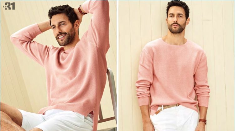 All smiles, Noah Mills sports a pink pastel drop-shoulder sweater with braided-belt chino Bermudas from LE 31. He also wears Paul Smith white sneakers and a Skagen Holst watch.