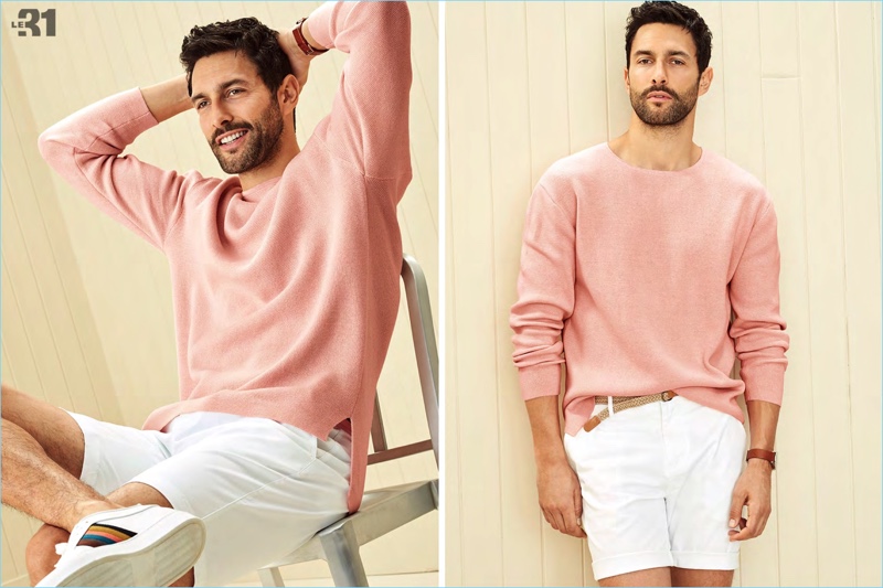 All smiles, Noah Mills sports a pink pastel drop-shoulder sweater with braided-belt chino Bermudas from LE 31. He also wears Paul Smith white sneakers and a Skagen Holst watch.