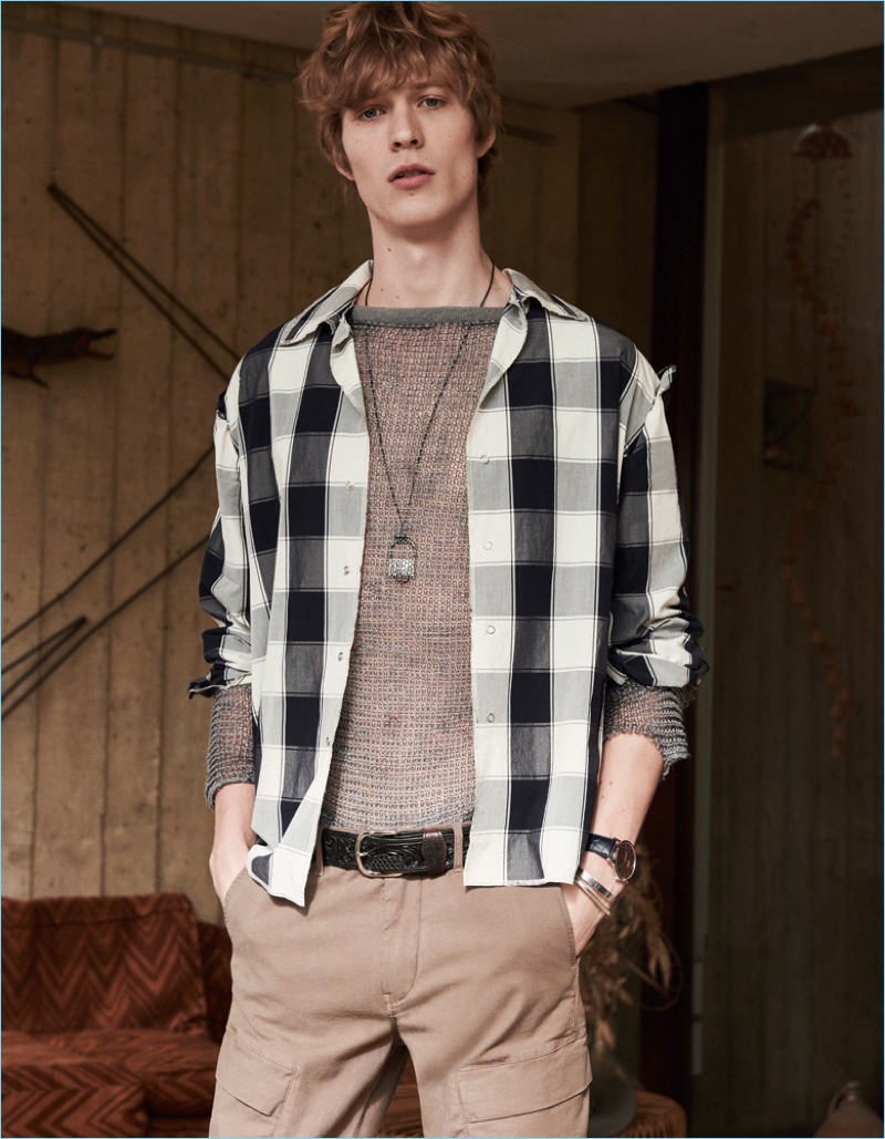 Front and center, Sven de Vries wears a check Maison Margiela shirt  and knit with IKKS pants.