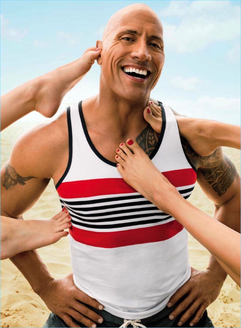 Hitting the beach with GQ, The Rock wears a Hilfiger Edition tank and Saturdays NYC shorts.