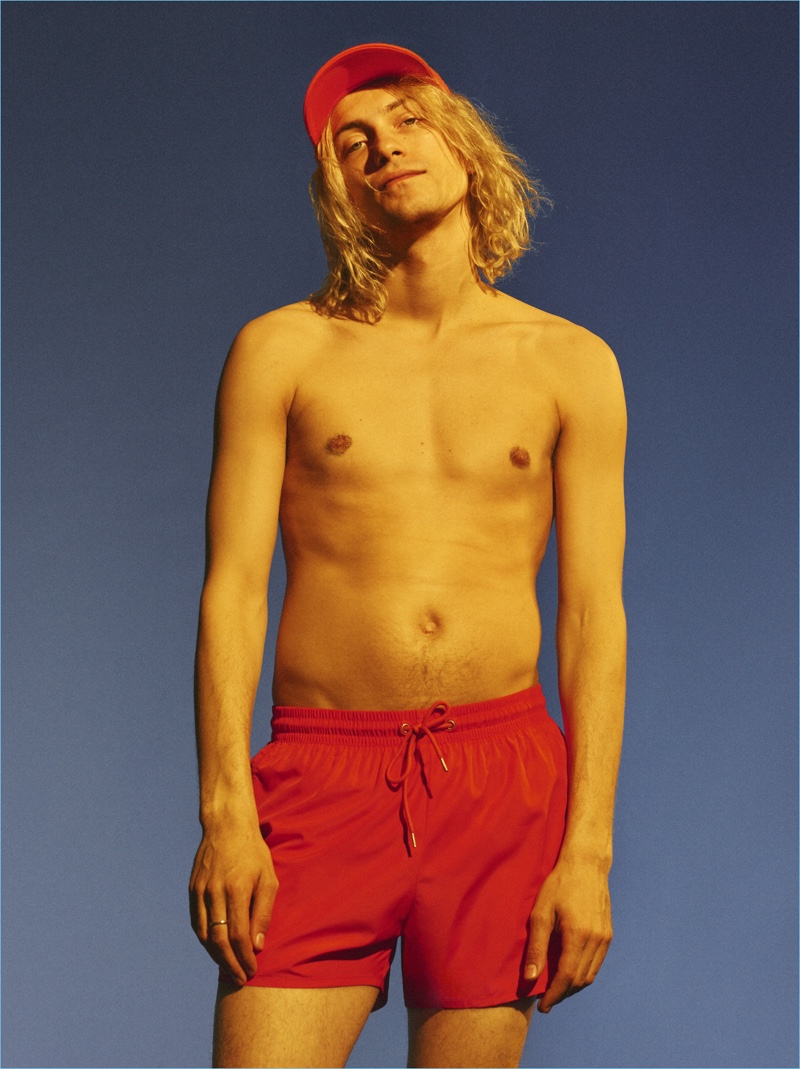 Luke Storey channels his inner lifeguard in a pair of red swim shorts from Weekday.