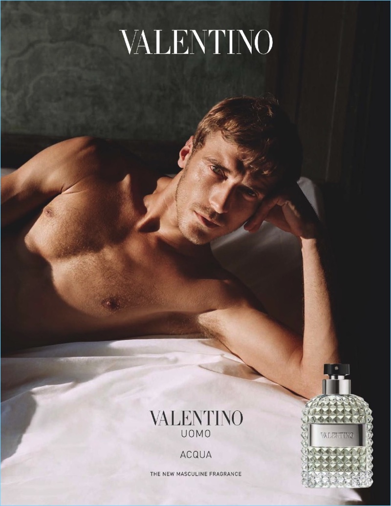Relaxing in bed, a shirtless Clément Chabernaud fronts the fragrance campaign for Valentino Uomo Acqua.