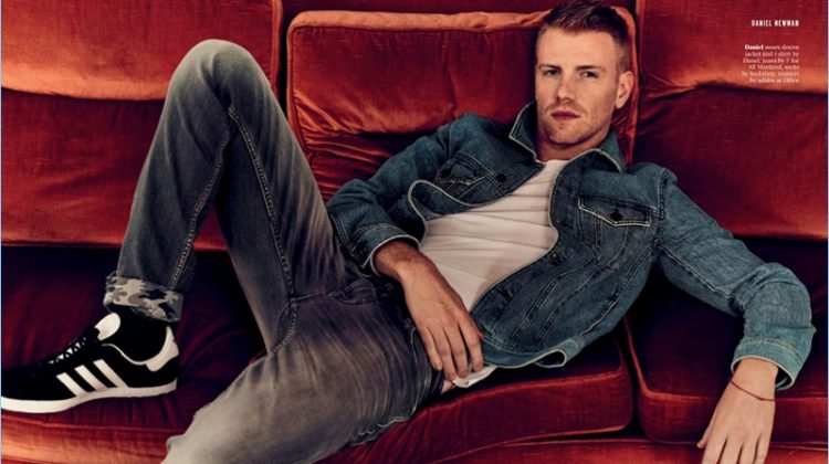 Relaxing, Daniel Newman wears a t-shirt and denim jacket by Diesel. He also sports 7 For All Mankind jeans and Adidas sneakers.