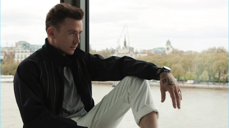 Taking in a quiet moment, Danny Jones wears an Aquascutum t-shirt, Grenfell jacket, Scotch & Soda jeans, and Oliver Sweeney sneakers.