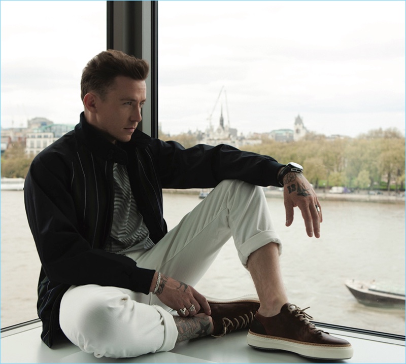 Taking in a quiet moment, Danny Jones wears an Aquascutum t-shirt, Grenfell jacket, Scotch & Soda jeans, and Oliver Sweeney sneakers.