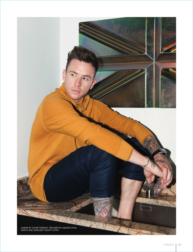 Appearing in a photo shoot for Candid magazine, Danny Jones wears an Oliver Sweeney sweater with Aquascutum trousers.