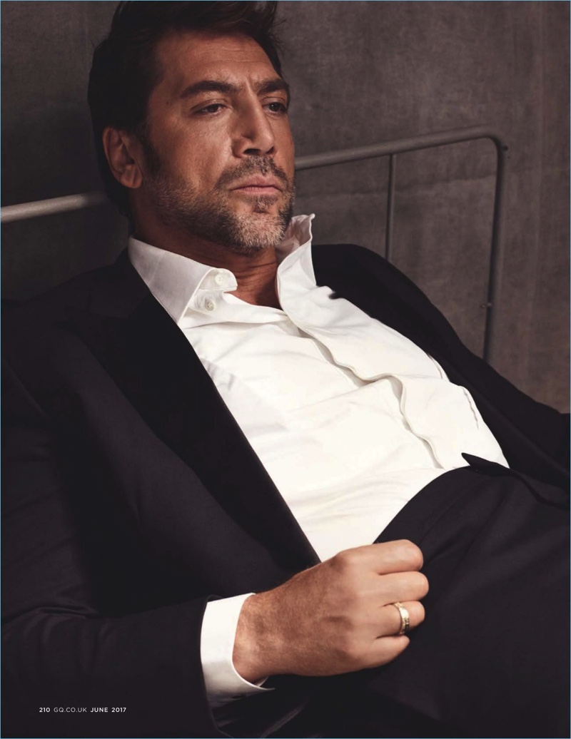 Relaxing, Javier Bardem dons a shirt and suit by Hermes.