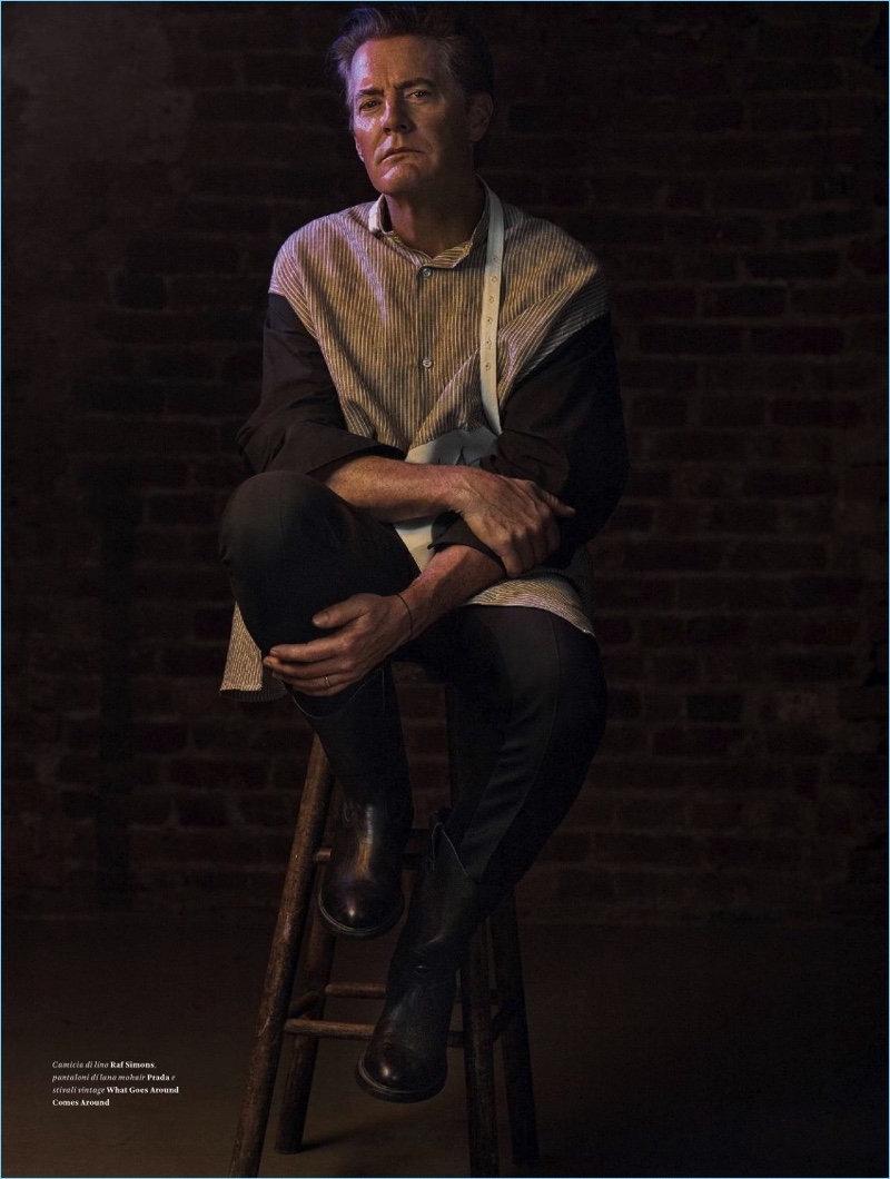 Sitting for a portrait, Kyle MacLachlan wears an oversized Raf Simons shirt with Prada pants and vintage boots from What Goes Around Comes Around.