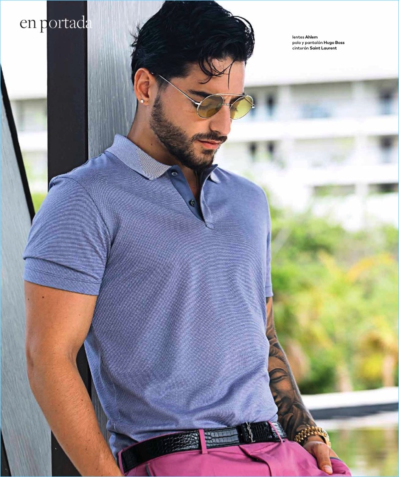 Soaking in the sun, Maluma wears Ahlem sunglasses with a polo and pants by Hugo Boss. Maluma also sports a Saint Laurent belt.