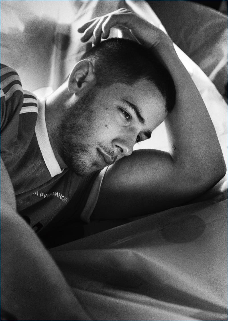 Appearing in a black and white photo, Nick Jonas wears an Adidas jersey.