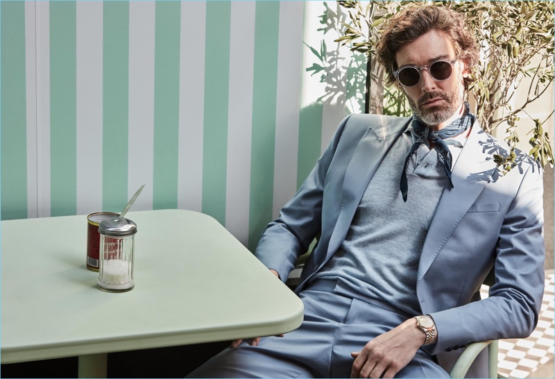 A chic vision, Richard Biedul dons a soft blue blazer $555 and pants $255 with a linen/wool polo $145. Richard accessorizes with a handkerchief and Reiss sunglasses.