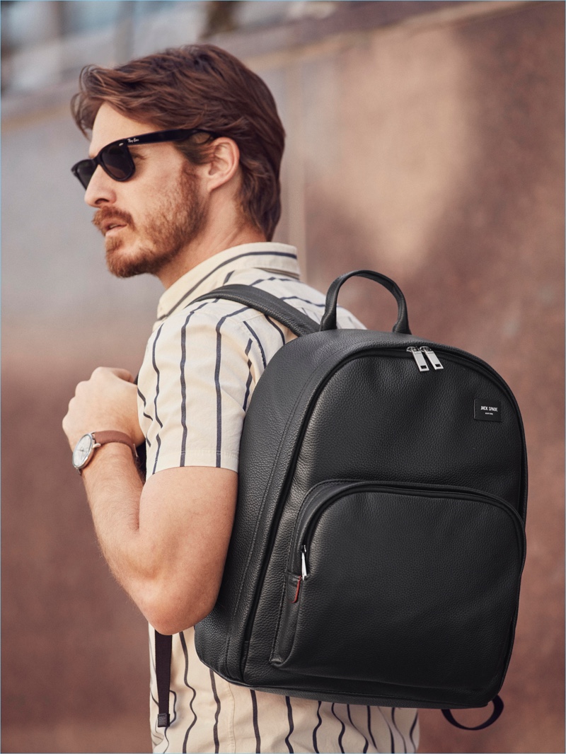 Heading out, Ryan Burns grabs a Jack Spade leather backpack.