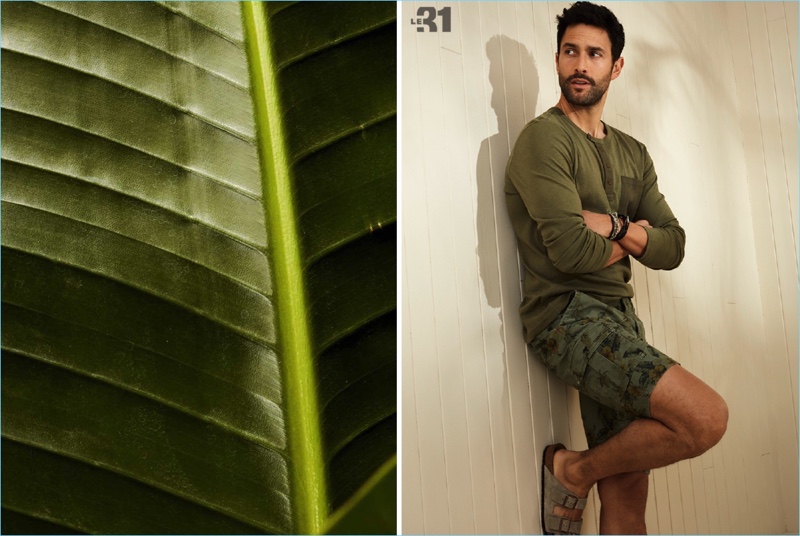 Dressed in green, Noah Mills wears a LE 31 heathered henley and urban utility Bermuda shorts with Birkenstock sandals.