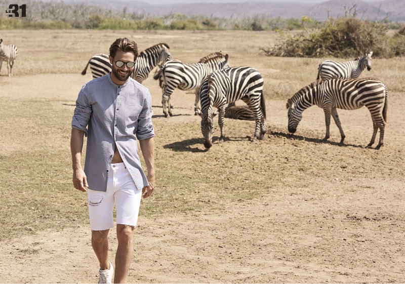 All smiles, John Halls wears a grandad collar seersucker shirt and sunglasses with Levi's white denim shorts.