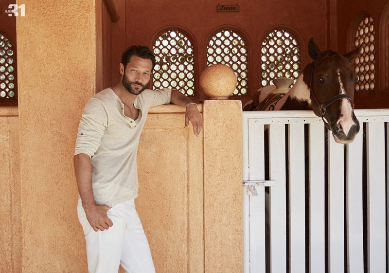 Model John Halls dons a LE 31 linen-knit henley sweater and Levi's white 511 jeans.