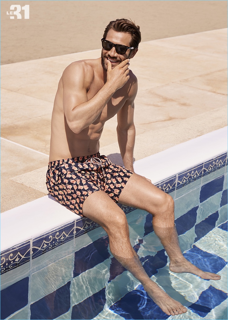 Summer ready, John Halls wears a pair of parrot print swim trunks from Scotch & Soda.