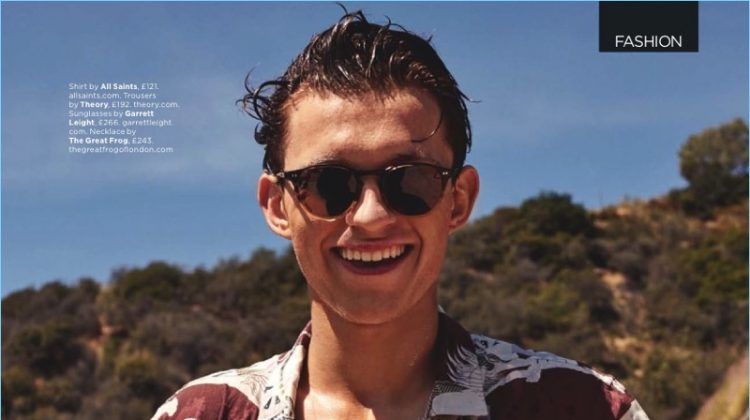 All smiles, Tom Holland wears an AllSaints shirt with Theory trousers and Garrett Leight sunglasses.