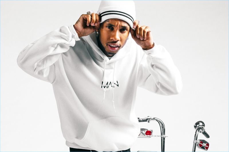 Rapper Tyga sports a boohooMAN MAN print hoodie $35 and white beanie $10.