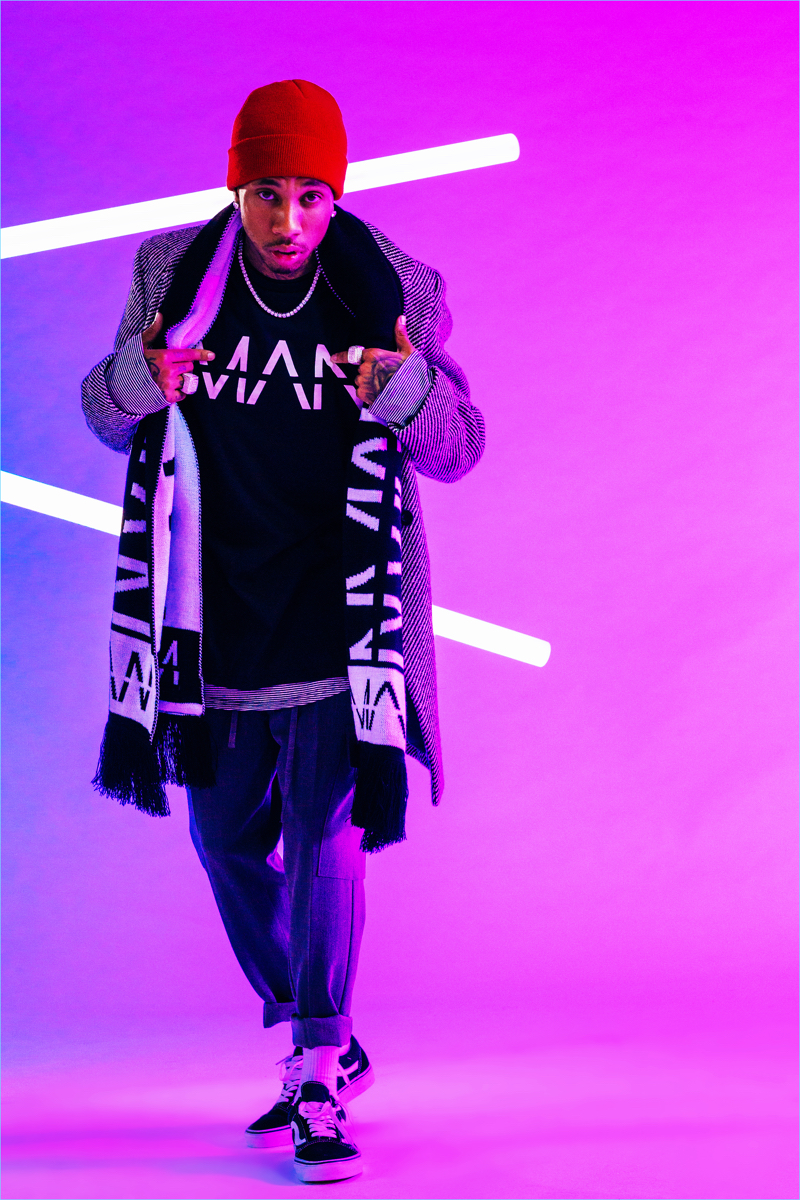 Taking to a photo studio, Tyga rocks a boohooMAN t-shirt $16, scarf $20, and tailored coat $52.