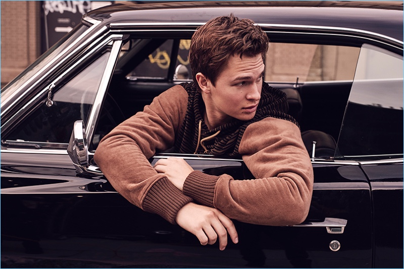 Sitting in a car, Ansel Elgort wears a hooded pullover by Junya Watanabe.