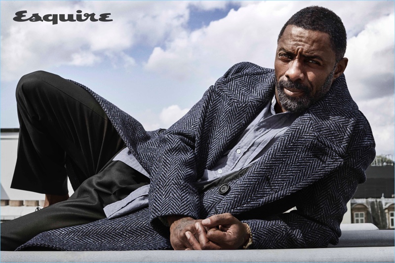 Ready for fall, Idris Elba wears a herringbone coat and smart pieces by Burberry.