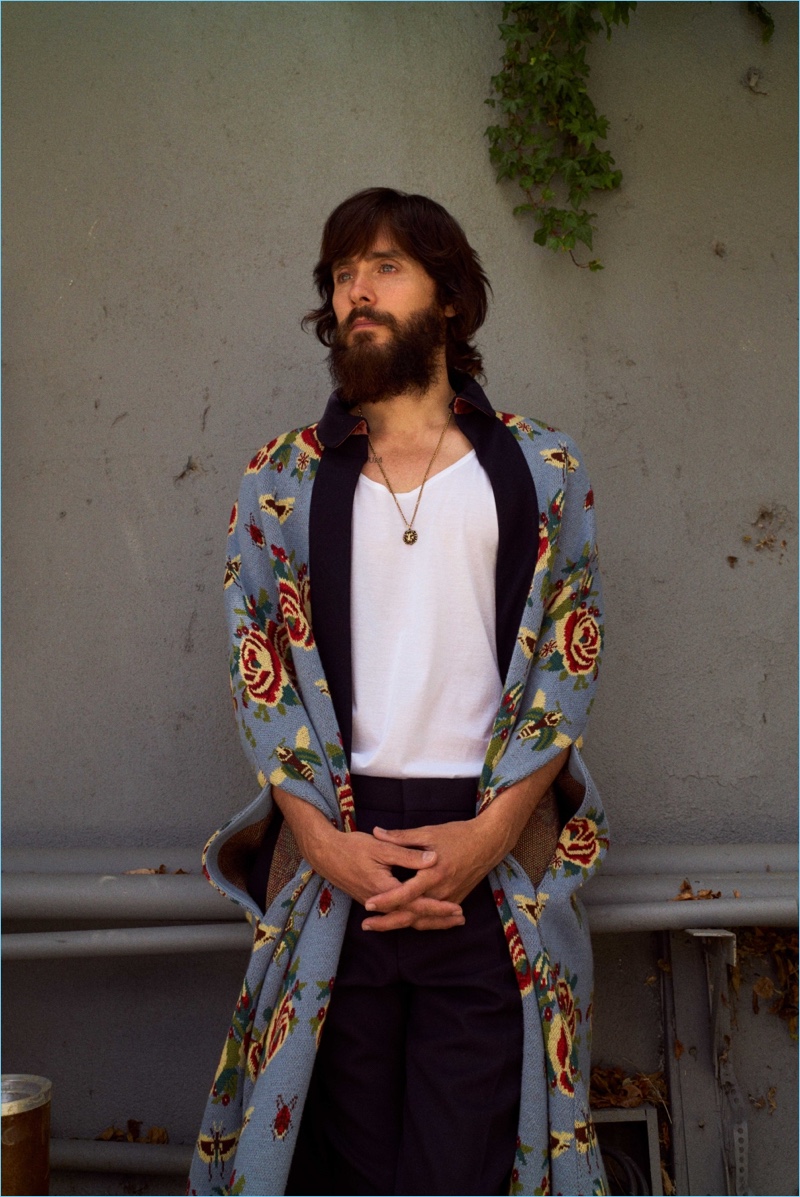 Jared Leto sports a necklace and floral print Gucci cape. He also wears a Sunspel tank and Alexander McQueen trousers.