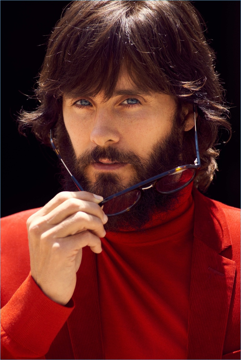 Standing out in red, Jared Leto wears a Dior Homme blazer, Versace turtleneck, and Carrera sunglasses.