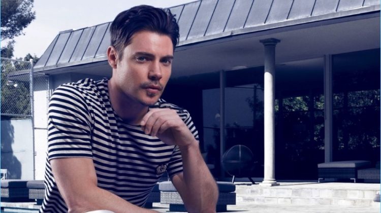 Relaxing outdoors, Josh Henderson wears a striped tee by The Kooples with AllSaints jeans, and Joseph Abboud dress shoes.