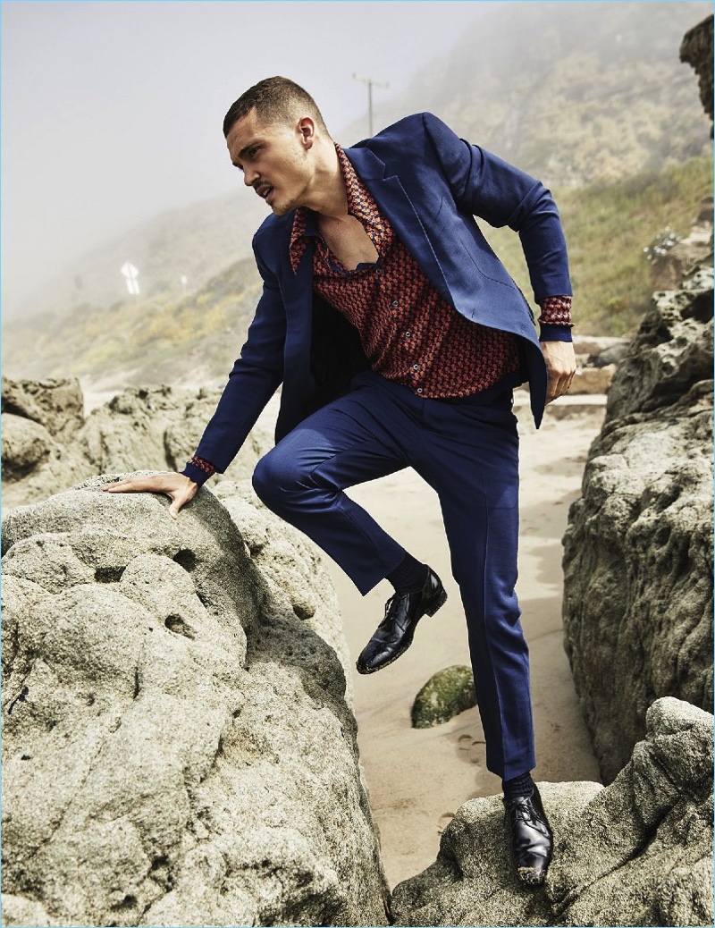 Embracing a charming blue, Karl Glusman wears a trim suit and patterned shirt by Prada.