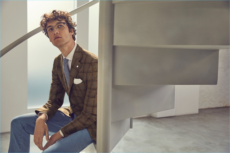 Wearing glasses, Marçal Taberner sports jeans with a plaid blazer from Luigi Bianchi Mantova's fall-winter 2017 collection.