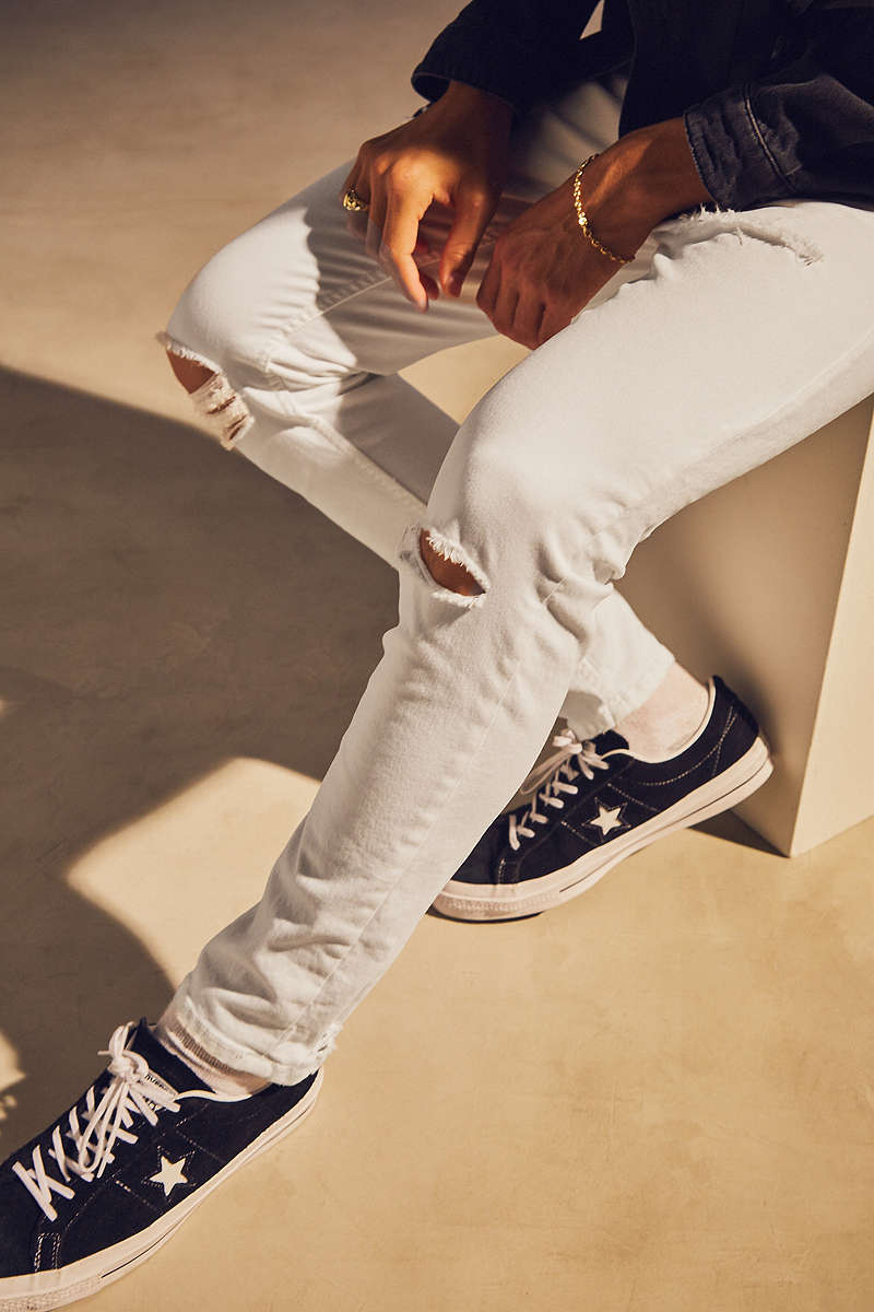 Neutral-colored sneakers are an effortless complement to white jeans while gold jewelry is timeless.