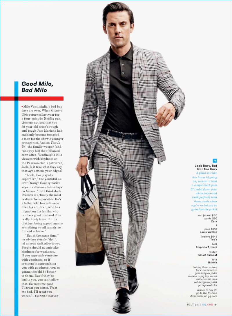 Making a check statement, Milo Ventimiglia wears a Zara suit, Louis Vuitton polo, Tod's loafers, and an Emporio Armani belt. He also sports a Smart Turnout watch and Shinola tote.
