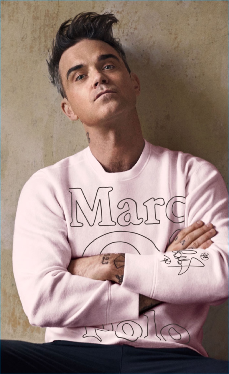 Robbie Williams wears a pink logo sweater from his Marc O'Polo collaboration.