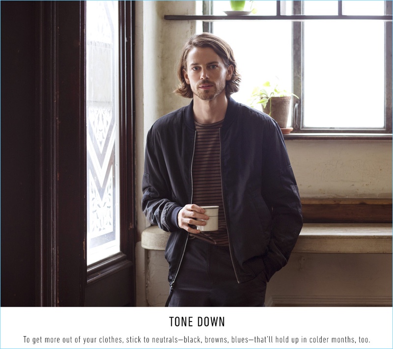 Enjoying a cup of coffee, Jeremy Young wears a Vince stripe tee $95, reversible bomber jacket $650, and drop crotch trousers $325.