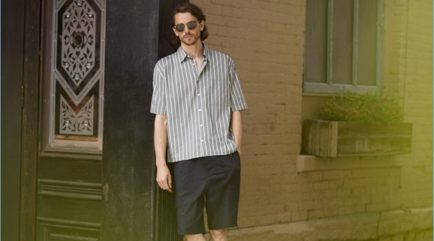 Take It Easy: Jeremy Young Models Relaxed Vince Looks for East Dane A summer vision, Jeremy Young wears a Vince stripe short-sleeve shirt $225, shorts $285, and slide sandals $95 with Paul Smith sunglasses $310.