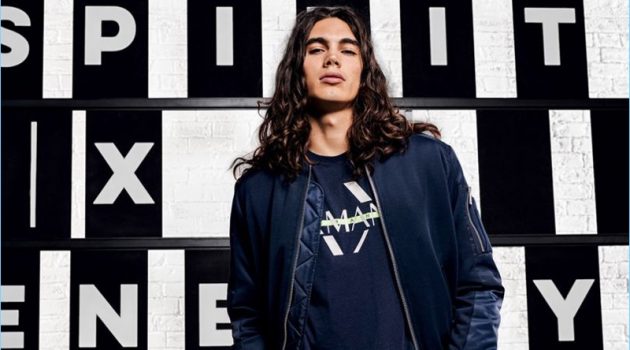 Vito Basso is a cool vision in a bomber jacket, graphic tee, and pants from Armani Exchange.